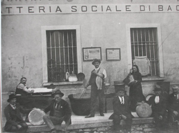 Gruppo di persone con attrezzi per la lavorazione del latte